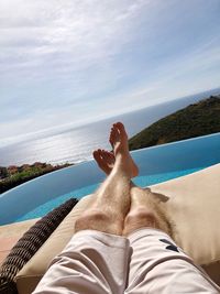 Low section of man relaxing in swimming pool