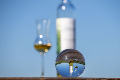 Low angle view of glass against clear blue sky