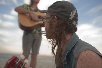 Friends playing music together on a beach