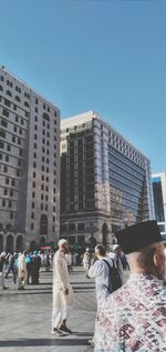 Rear view of people against buildings in city