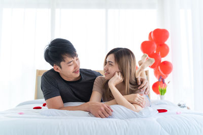 Young couple kissing on bed at home