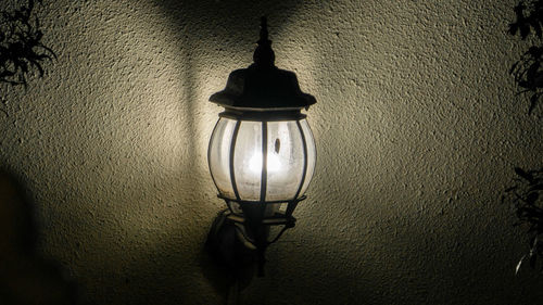 Close-up of light bulb hanging against wall