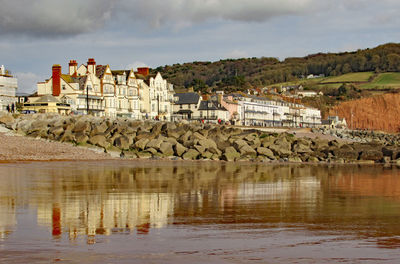 Scenic view of lake and buildings against sky