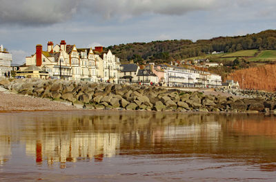 Scenic view of lake and buildings against sky