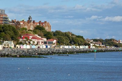 Buildings by sea against sky in city