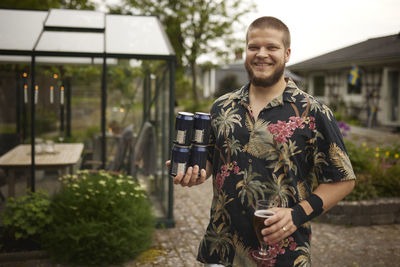 Smiling man holding beer cans