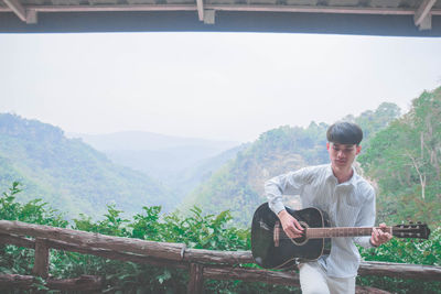 Side view of young man using mobile phone