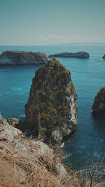 Rocks on sea shore against sky