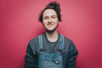 Portrait of smiling young man against red background