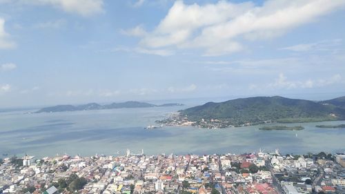 High angle view of city by sea against sky