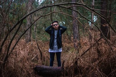 Portrait of man wearing sunglasses while standing in forest