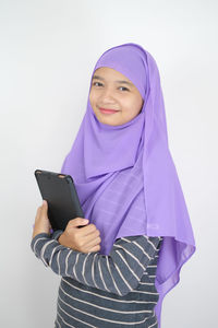 Portrait of a smiling young woman against white background