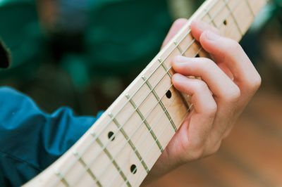 Midsection of man playing guitar