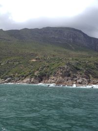 Scenic view of sea and mountains against sky