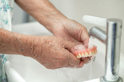 Cropped hand of man washing hands