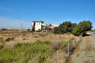 Built structure on landscape against blue sky