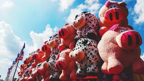 Low angle view of stuffed toys against sky at amusement park