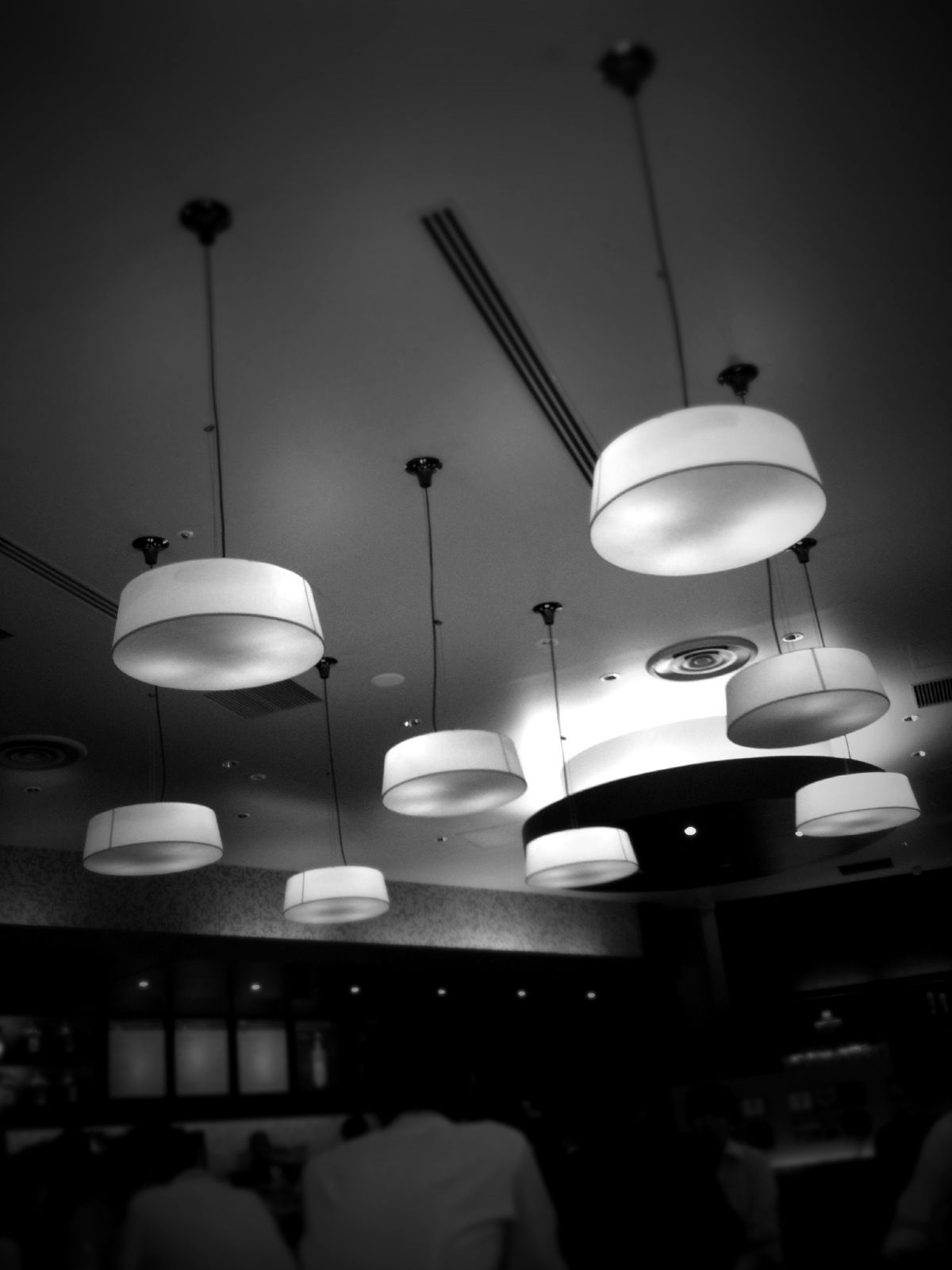 indoors, illuminated, lighting equipment, electric lamp, in a row, electricity, table, ceiling, electric light, hanging, lamp, light - natural phenomenon, large group of objects, still life, arrangement, light bulb, restaurant, low angle view, no people, night