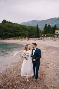 Newlywed couple walking on beach