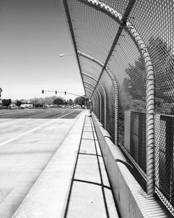 Fence by road against sky