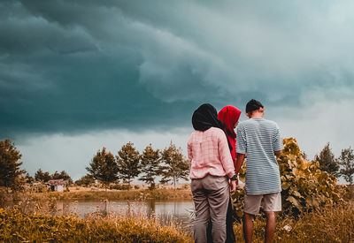 Rear view of couple standing against sky