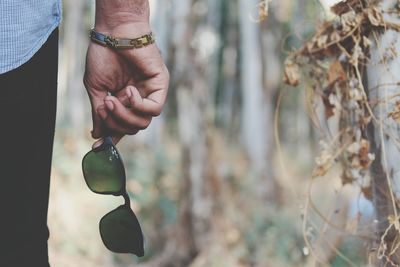 Cropped image of man hand holding sunglasses