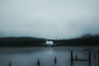 Airplane on runway at yanji chaoyangchuan airport against sky during rainy season