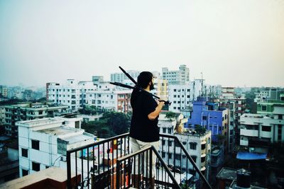 Man in city against clear sky