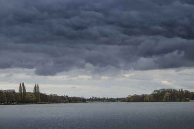 Storm clouds over trees against sky