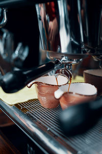 Close-up of coffee pouring in cup at cafe