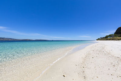 Scenic view of beach against blue sky