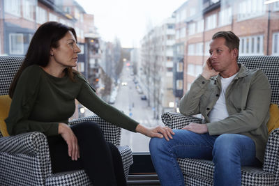 Man and woman sitting in armchairs