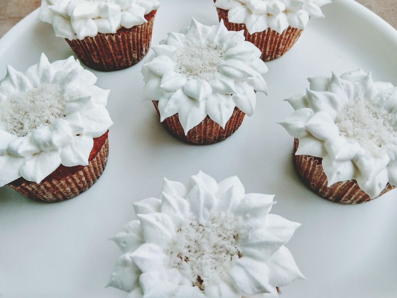 indulgence, food and drink, high angle view, sweet food, still life, white color, food, cupcake, table, dessert, no people, freshness, unhealthy eating, indoors, temptation, flower, celebration, day, close-up, white background, ready-to-eat, flower head