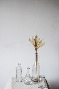 Flower vase on table against wall