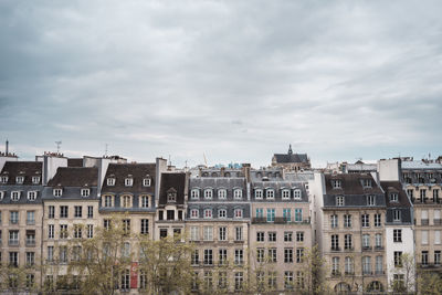 Buildings against cloudy sky