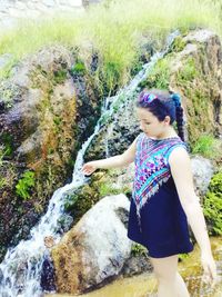 Full length of girl standing on rock in water