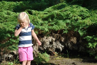 Cute girl standing against plants