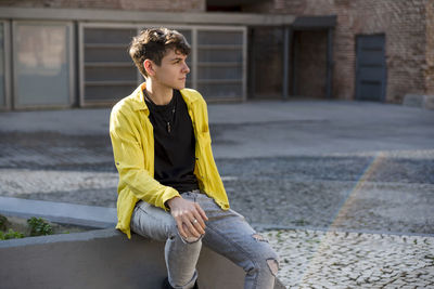 Portrait of a non binary person looking at camera while posing outdoors. person