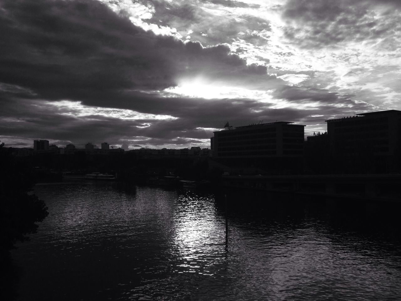 building exterior, water, sky, architecture, built structure, waterfront, cloud - sky, river, city, reflection, cloudy, cloud, rippled, sunset, lake, silhouette, residential building, nature, outdoors, no people