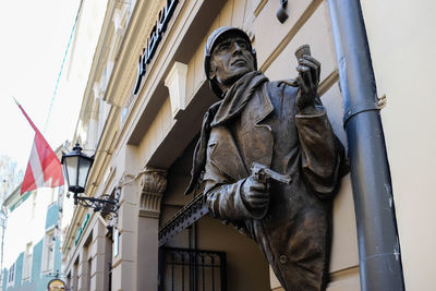 Bronze statue of sherlock holmes on a building in riga