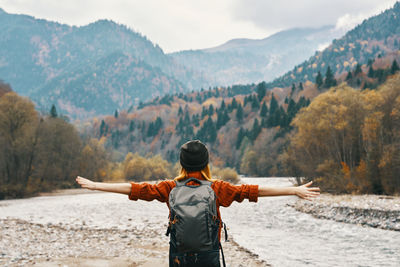 Rear view of man looking at mountains against sky