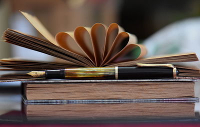 Close-up of fountain pen with books