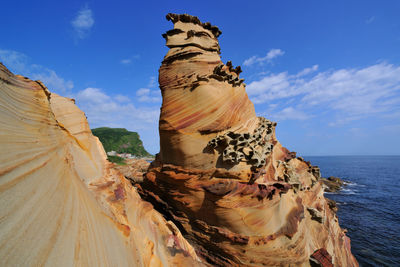 Rock formations by sea against sky