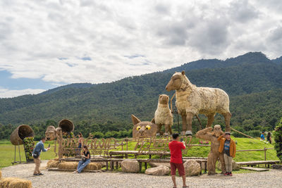 Rear view of people on mountain against sky