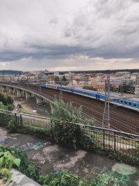 Bridge over river in city against sky
