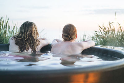 Rear view of woman swimming in bath