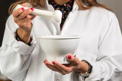 Close-up of pharmacist holding mortar and pestle