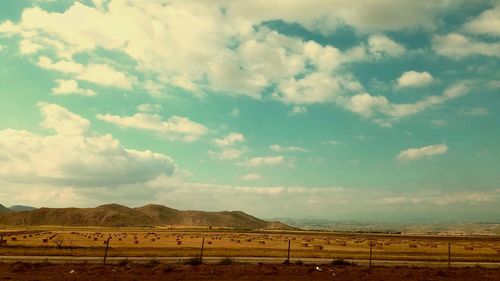 Scenic view of field against cloudy sky