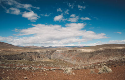 View of desert against cloudy sky