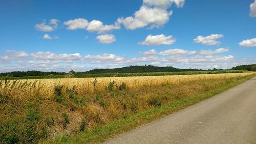 Scenic view of field against cloudy sky